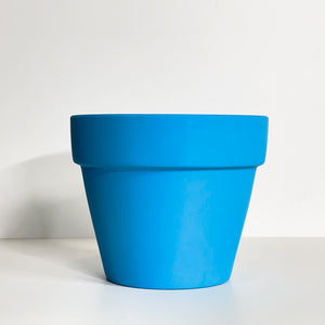 A blue terracotta pot with a matte finish. The planter pot includes a drainage hole.