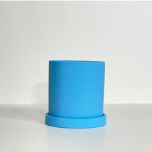 Load image into Gallery viewer, The Cyn is a sky blue cylinder-shaped planter pot. The planter pot has a drainage hole and a saucer that helps catch water.
