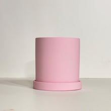 Load image into Gallery viewer, The Cyn is a baby pink cylinder-shaped planter pot. The planter pot has a drainage hole and a saucer that helps catch water.
