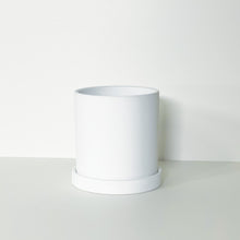 Load image into Gallery viewer, The Cyn is a white cylinder-shaped planter pot. The planter pot has a drainage hole and a saucer that helps catch water.
